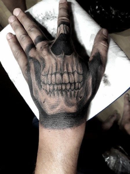 sonrisa tatuajes de calaveras en la mano